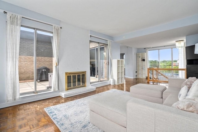living room featuring a glass covered fireplace and baseboards