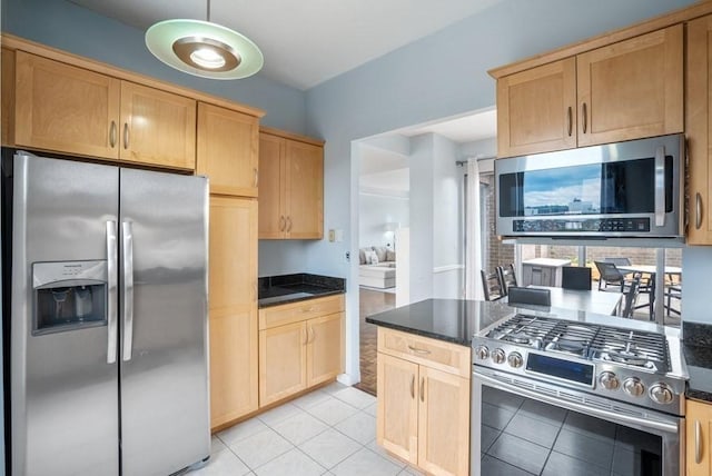 kitchen with stainless steel appliances, light brown cabinetry, and light tile patterned floors