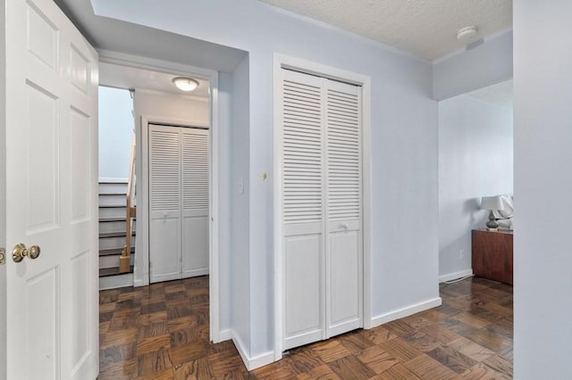 hallway with baseboards and a textured ceiling