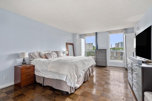 bedroom with a textured ceiling and baseboards