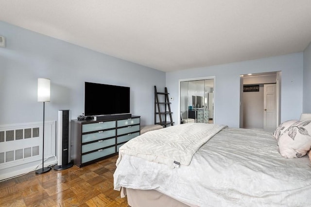bedroom with radiator heating unit and a closet