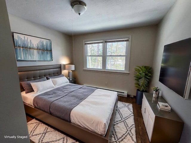 bedroom featuring baseboard heating and wood finished floors