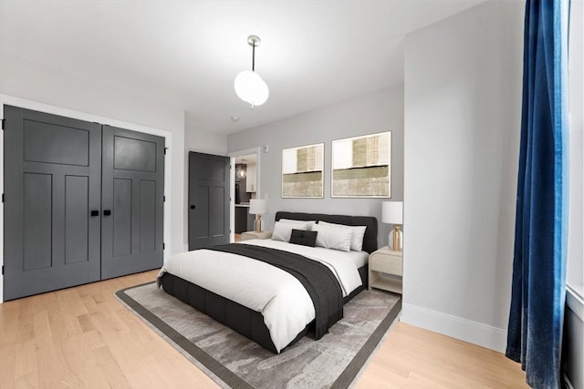 bedroom featuring a closet, baseboards, and light wood-style flooring