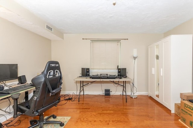 office space with baseboards, wood finished floors, and visible vents