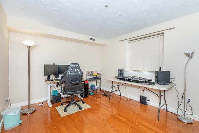 office featuring visible vents, baseboards, and wood finished floors