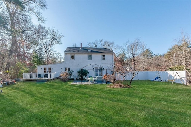 back of property featuring a patio area, a yard, and a wooden deck