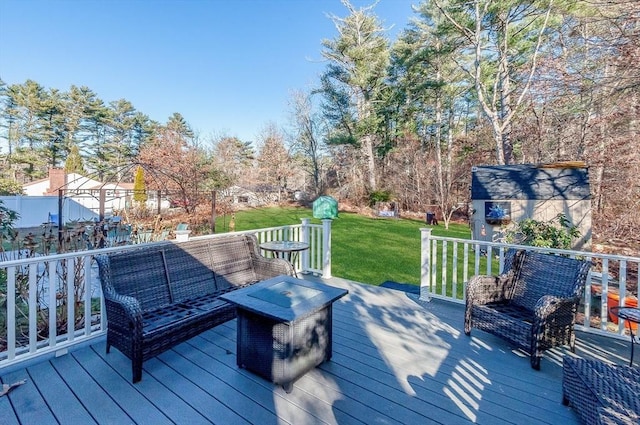 deck with a lawn, an outdoor living space, and a shed