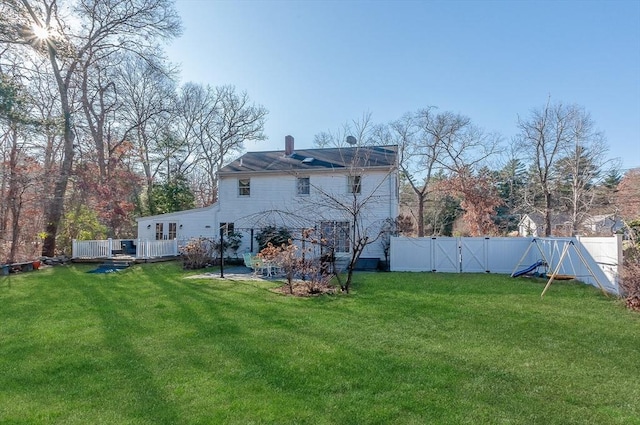 back of property with a yard and a deck