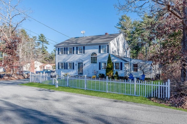 colonial home featuring a front lawn