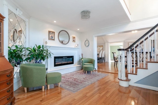 living room with light hardwood / wood-style flooring and crown molding