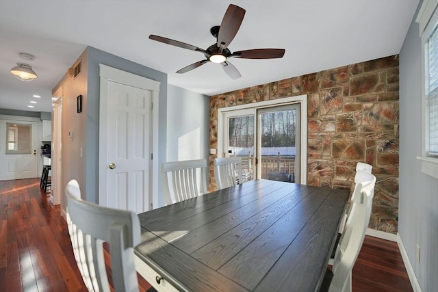 unfurnished dining area featuring ceiling fan and dark hardwood / wood-style floors