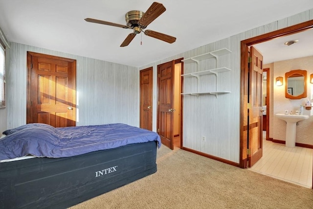 carpeted bedroom with ceiling fan, sink, and connected bathroom