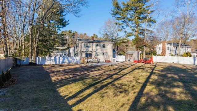 back of house featuring a lawn and a storage shed