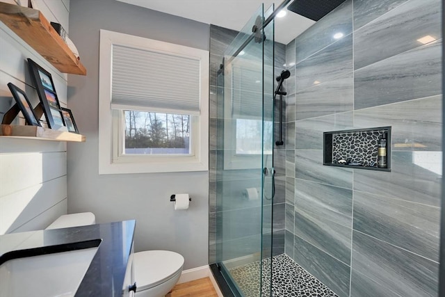 bathroom with toilet, wood-type flooring, a shower with door, and vanity