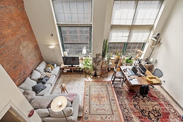 200 Market St Unit 44B, Lowell, MA 01852 - living area with a high ceiling, brick wall, wood finished floors, and baseboards
