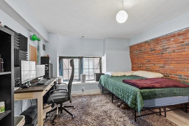 200 Market St Unit 44B, Lowell, MA 01852 - bedroom featuring wood finished floors, an office area, and brick wall