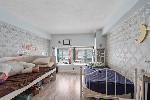 200 Market St Unit 44B, Lowell, MA 01852 - living room featuring wallpapered walls, wood finished floors, baseboards, and a textured ceiling