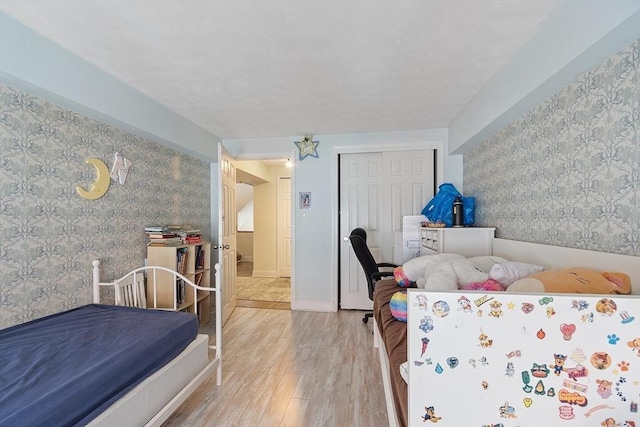 200 Market St Unit 44B, Lowell, MA 01852 - bedroom featuring wallpapered walls, wood finished floors, and a closet