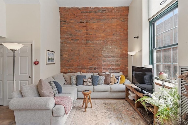 200 Market St Unit 44B, Lowell, MA 01852 - living area with a towering ceiling, brick wall, and wood finished floors