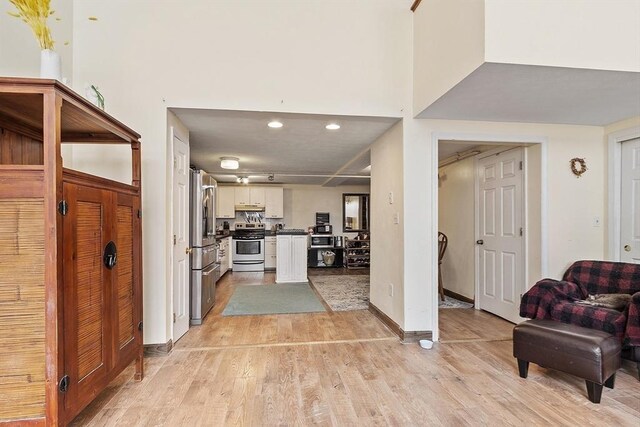 200 Market St Unit 44B, Lowell, MA 01852 - kitchen with appliances with stainless steel finishes, light wood-style flooring, open floor plan, dark countertops, and under cabinet range hood
