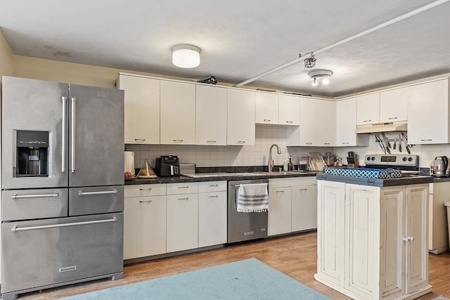 200 Market St Unit 44B, Lowell, MA 01852 - kitchen featuring stainless steel appliances, under cabinet range hood, light wood-type flooring, and dark countertops