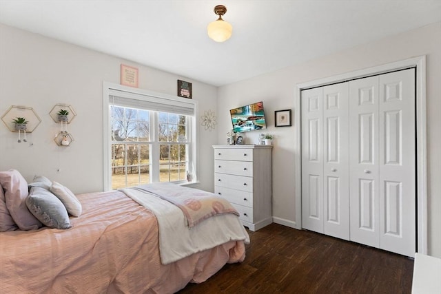 bedroom featuring a closet, dark wood finished floors, and baseboards