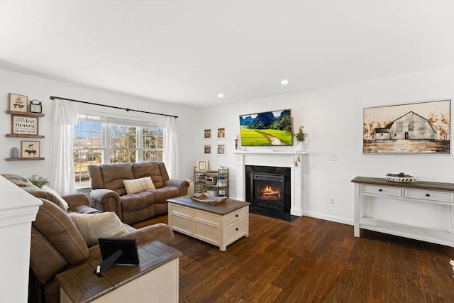 living area with a fireplace with flush hearth, baseboards, dark wood-type flooring, and recessed lighting