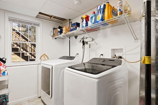 laundry area featuring laundry area, washing machine and dryer, and baseboards