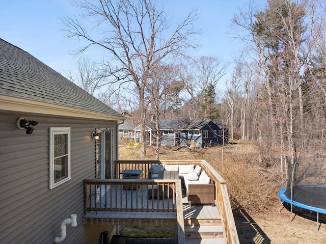 deck with a trampoline and an outdoor living space