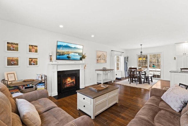 living room with a fireplace with flush hearth, dark wood finished floors, and recessed lighting