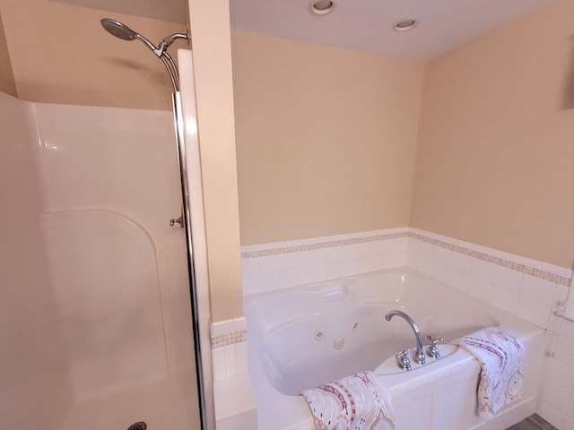 bathroom featuring a jetted tub and a stall shower