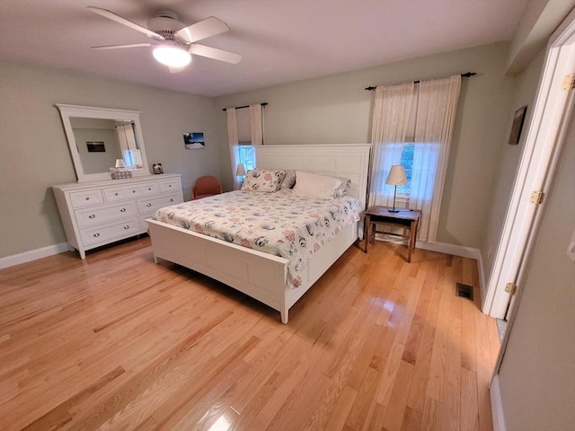 bedroom with a ceiling fan, light wood-style flooring, baseboards, and visible vents
