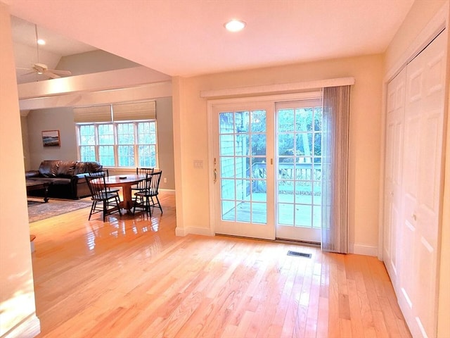 doorway featuring a ceiling fan, wood finished floors, visible vents, and baseboards
