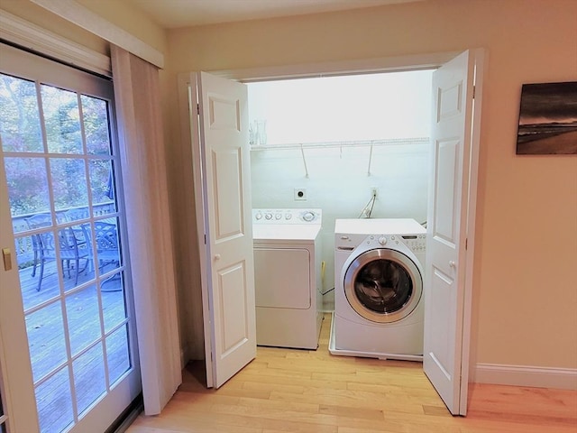 laundry room featuring laundry area, baseboards, light wood finished floors, and washing machine and clothes dryer