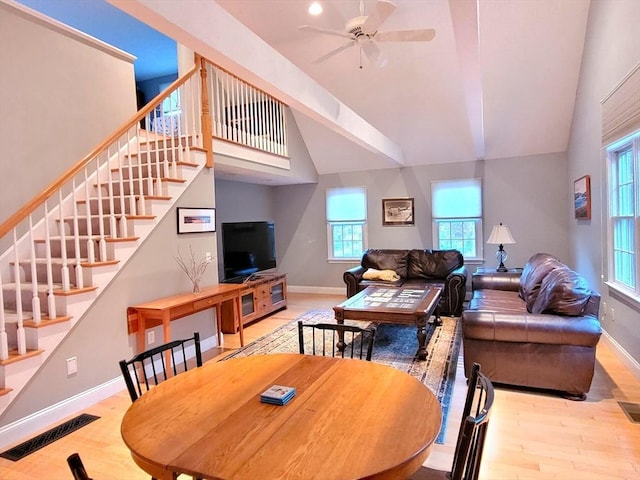 dining room featuring visible vents, wood finished floors, a ceiling fan, and stairway