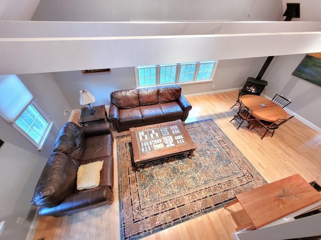 living room with baseboards, wood finished floors, and a wood stove