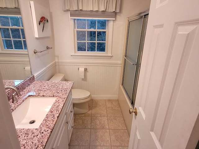 full bath featuring vanity, toilet, a wainscoted wall, and enclosed tub / shower combo