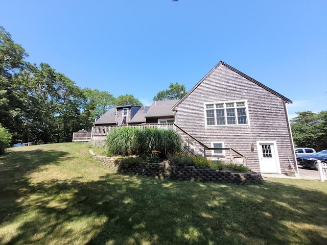 rear view of house featuring a yard, a deck, and stairs