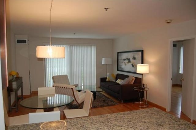 living room with visible vents, baseboards, and wood finished floors