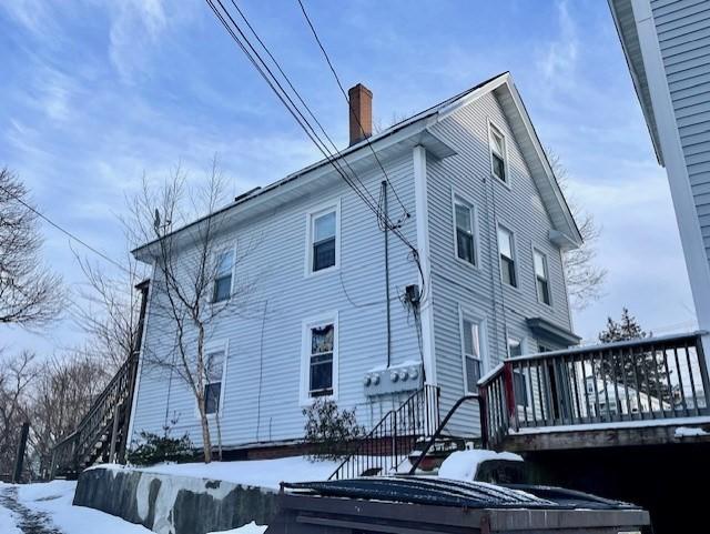 snow covered property with a wooden deck