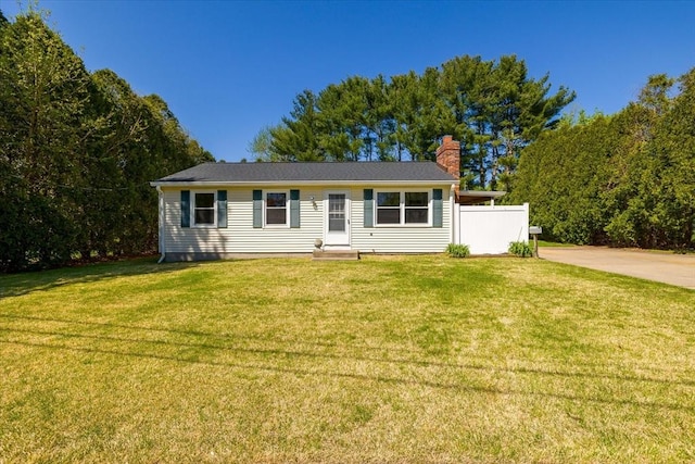 ranch-style house featuring fence, a chimney, and a front lawn