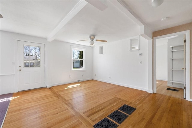 foyer featuring light wood-style floors, a ceiling fan, visible vents, and beamed ceiling