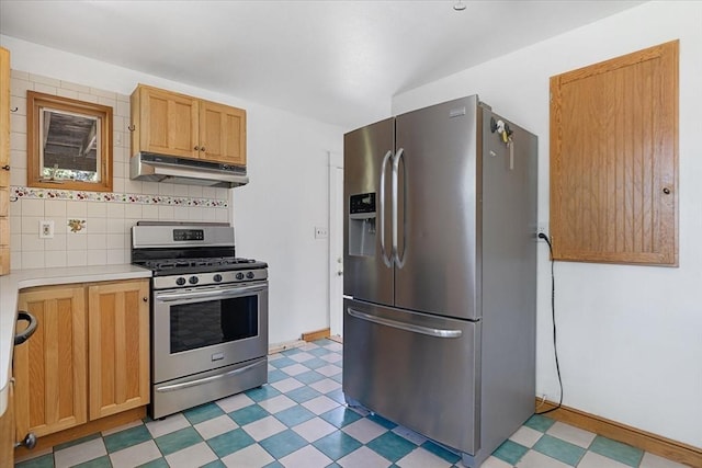 kitchen featuring decorative backsplash, light floors, light countertops, under cabinet range hood, and stainless steel appliances