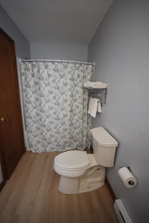 343 Chicopee St Unit 41, Chicopee, MA 01013 - bathroom with a baseboard heating unit, toilet, wood finished floors, a textured ceiling, and a shower with curtain