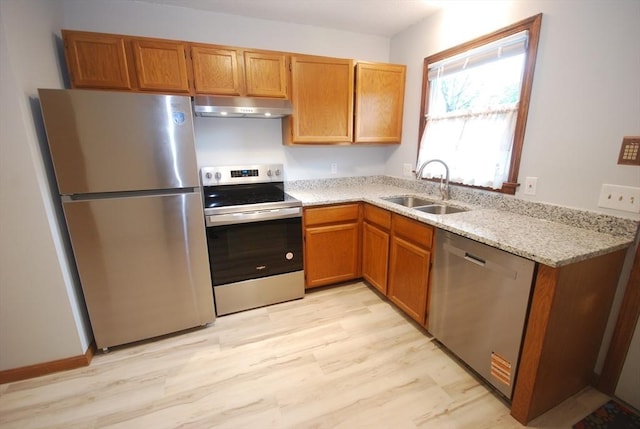 343 Chicopee St Unit 41, Chicopee, MA 01013 - kitchen featuring appliances with stainless steel finishes, under cabinet range hood, a sink, and light wood-style flooring