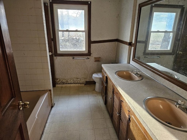 full bathroom featuring a wealth of natural light, tile patterned floors, and a sink