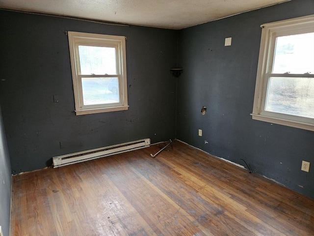 unfurnished room featuring a baseboard radiator and wood finished floors