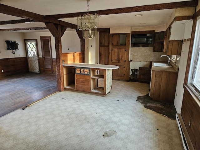 kitchen featuring a baseboard radiator, a sink, beam ceiling, and light floors