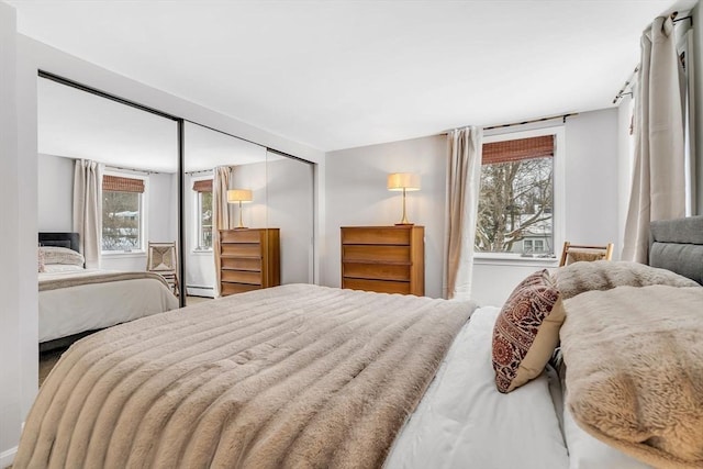 bedroom with a baseboard radiator and a closet