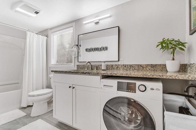 bathroom with toilet, tile patterned floors, vanity, shower / tub combo with curtain, and washer / dryer